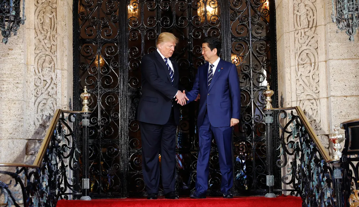 Presiden AS, Donald Trump menyambut kedatangan PM Jepang Shinzo Abe dalam pertemuan mereka di Resor Mar-a-Lago, Florida, Selasa (17/4). Pertemuan digunakan untuk mencari pemahaman bersama mengenai masalah nuklir Korea Utara. (AP/Pablo Martinez Monsivais)