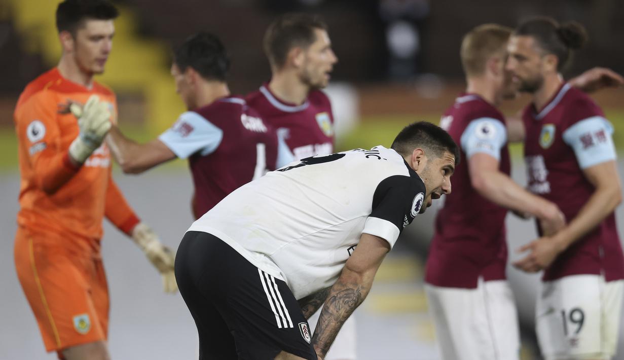 Ekspresi kecewa Striker Fulham, Aleksandar Mitrovic (tengah) usai dikalahkan Burnley 0-2 dalam laga lanjutan Liga Inggris 2020/2021 pekan ke-35 di Craven Cottage Stadium, London, Senin (10/5/2021). Fulham dipastikan terdegradasi musim depan. (AP/Clive Rose/Pool)