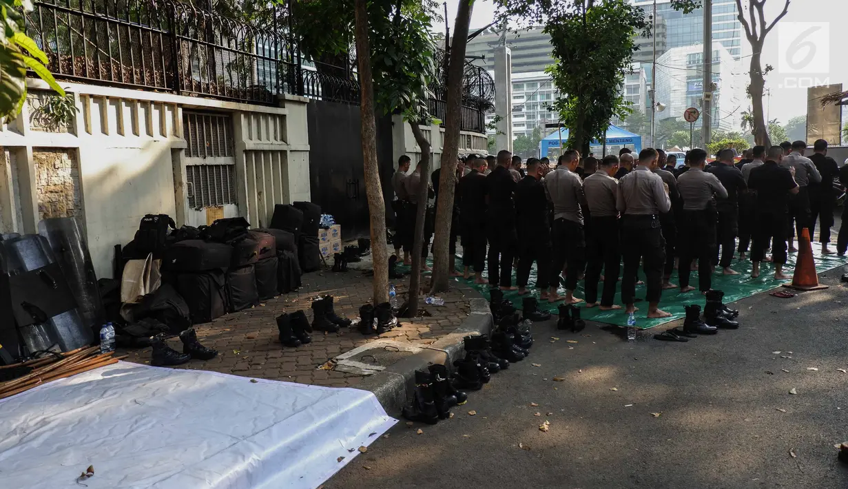 Pasukan Brimob menunaikan ibadah salat Ashar berjamaah disela pengamanan di kawasan Bundaran HI, Jakarta, Rabu (29/5/2019). Di tengah tugas mengamankan situasi, para anggota Brimob tak lupa untuk tetap menjalankan kewajibannya sebagai umat beragama. (Liputan6.com/Faizal Fanani)