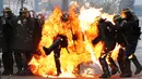 Seorang perwira polisi Prancis terbakar dalam bentrokan dengan pengunjuk rasa perayaan May Day di Paris, Senin (1/5). Satu polisi mengalami luka bakar serius dan dua lainnya luka-luka dalam bentrokan yang melibatkan bom molotov. (Zakaria ABDELKAFI/AFP)