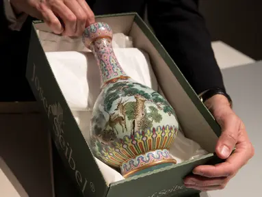 Sebuah vas China antik yang diyakini berasal dari masa Dinasti Qing pada abad ke-18 diperlihatkan di rumah lelang Sotheby, Paris, Selasa (22/5). Vas China antik berusia ratusan tahun akan dilelang di Prancis pada bulan depan. (AFP/Thomas SAMSON)