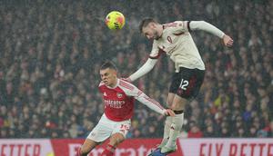 Pemain Liverpool, Conor Bradley, menyundul bola di atas pemain Arsenal, Leandro Trossard, dalam pertandingan Liga Inggris di stadion Emirates, Jumat (9/1/2026). (AP Photo/Ian Walton)