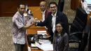 Calon Pimpinan KPK Nurul Ghufron berjabat tangan dengan Ketua Komisi III DPR Aziz Syamsuddin (kanan) usai menerima amplop berisi tema makalah yang harus dibuat, saat uji kelayakan dan kepatutan capim KPK di Kompleks Parlemen, Senayan, Jakarta, Senin (9/9/2019). (Liputan6.com/Johan Tallo)