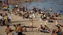 Seorang wanita minum sambil menikmati cuaca panas di pantai di Barcelona, Spanyol, Kamis (12/8/2021). Layanan cuaca nasional Spanyol memperingatkan suhu bisa mencapai 44 derajat Celcius (111 derajat Fahrenheit) di beberapa daerah dalam beberapa hari mendatang. (AP Photo/Joan Mateu Parra)