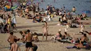 Seorang wanita minum sambil menikmati cuaca panas di pantai di Barcelona, Spanyol, Kamis (12/8/2021). Layanan cuaca nasional Spanyol memperingatkan suhu bisa mencapai 44 derajat Celcius (111 derajat Fahrenheit) di beberapa daerah dalam beberapa hari mendatang. (AP Photo/Joan Mateu Parra)