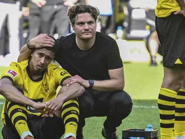 Kenyataan pahit harus diterima skuad Borussia Dortmund setelah berakhirnya laga pekan terakhir Liga Jerman 2022/2023 menghadapi FSV Mainz di Dortmund, Jerman, Sabtu (27/5/2023). Hanya bermain imbang 2-2, gelar juara yang sudah di depan mata pun melayang ke Bayern Munchen. Aura kesedihan dan kekecewaan pun menyelimuti seluruh anggota skuad Borussia Dortmund, seperti yang terekam dalam beberapa foto berikut ini. (AP Photo/Michael Probst)