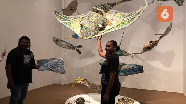 Seniman dari Erub Arts, Jimmy John Thaiday (kiri), Lavinia Ketchell (kanan) di depan karya Ghost Nets: Awakening the Drifting Giants.