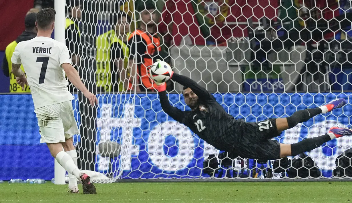 Kiper Portugal, Diogo Costa menggagalkan tendangan pemain Slovenia, Benjamin Verbic pada babak adu penalti saat babak 16 besar Euro 2024 di Frankfurt Arena, Frankfurt, Jerman, Senin (02/07/2024) WIB. (AP Photo/Antonio Calanni)