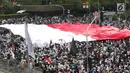 Peserta aksi massa Gerakan Nasional Kedaulatan Rakyat mengibarkan bendera Merah Putih raksasa saat melakukan unjuk rasa di perempatan dekat Gedung Bawaslu, Jakarta, Rabu (22/5/2019). Dalam aksinya mereka meminta Bawaslu memeriksa kembali hasil Pemilu 2019. (Liputan6.com/Helmi Fithriansyah)