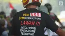 Seorang warga mengenakan kaus yang bertuliskan "Lawan Intoleransi, Radikalisme dan Terorisme" saat akan menghadiri Rembuk Nasional Aktivis 98 di JIExpo Kemayoran, Jakarta, Jakarta, Sabtu (7/7). (Merdeka.com/Imam Buhori)