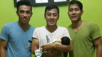 Samsul Arif menggendong anak pertamanya, Syua Thafana Arane, diapit dua pemain Arema Cronus, Benny Wahyudi dan Purwaka Yudi. (Bola.com/Kevin Setiawan)