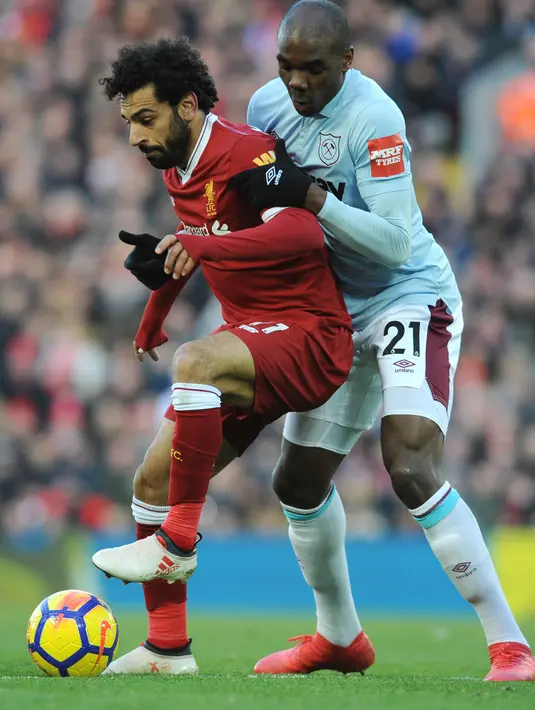 Penyerang Liverpool, Mohamed Salah berusaha mengontrol bola dari kawalan pemain West Ham United, Angelo Ogbonna pada lanjutan Liga Inggris di Anfield, Inggris (24/2). Liverpool menang telak atas West Ham 4-1. (AP Photo / Rui Vieira)