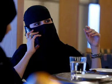 Seorang wanita bercadar berbicara di ponsel di sebuah kafe di Riyadh, Arab Saudi (6/10). (REUTERS/Faisal Al Nasser)