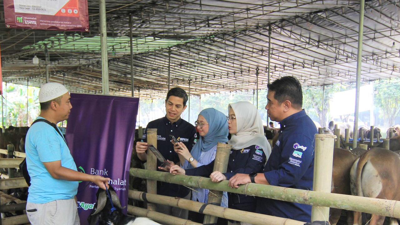 Sekretaris Perusahaan PT Bank Muamalat Indonesia Tbk Hayunaji (kedua kiri) menyaksikan nasabah melakukan pembelian hewan kurban untuk Idul Adha 2023 menggunakan fitur QRIS Muamalat DIN di salah satu pusat penjualan hewan di Bintaro Jaya.