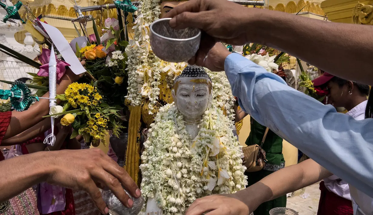 Para umat menuangkan air ke patung Buddha di Pagoda Shwedagon untuk menandai Hari Ulang Tahun Buddha, yang jatuh pada Hari Bulan Purnama Kasone, di Yangon pada 11 Mei 2025. (Sai Aung MAIN/AFP)