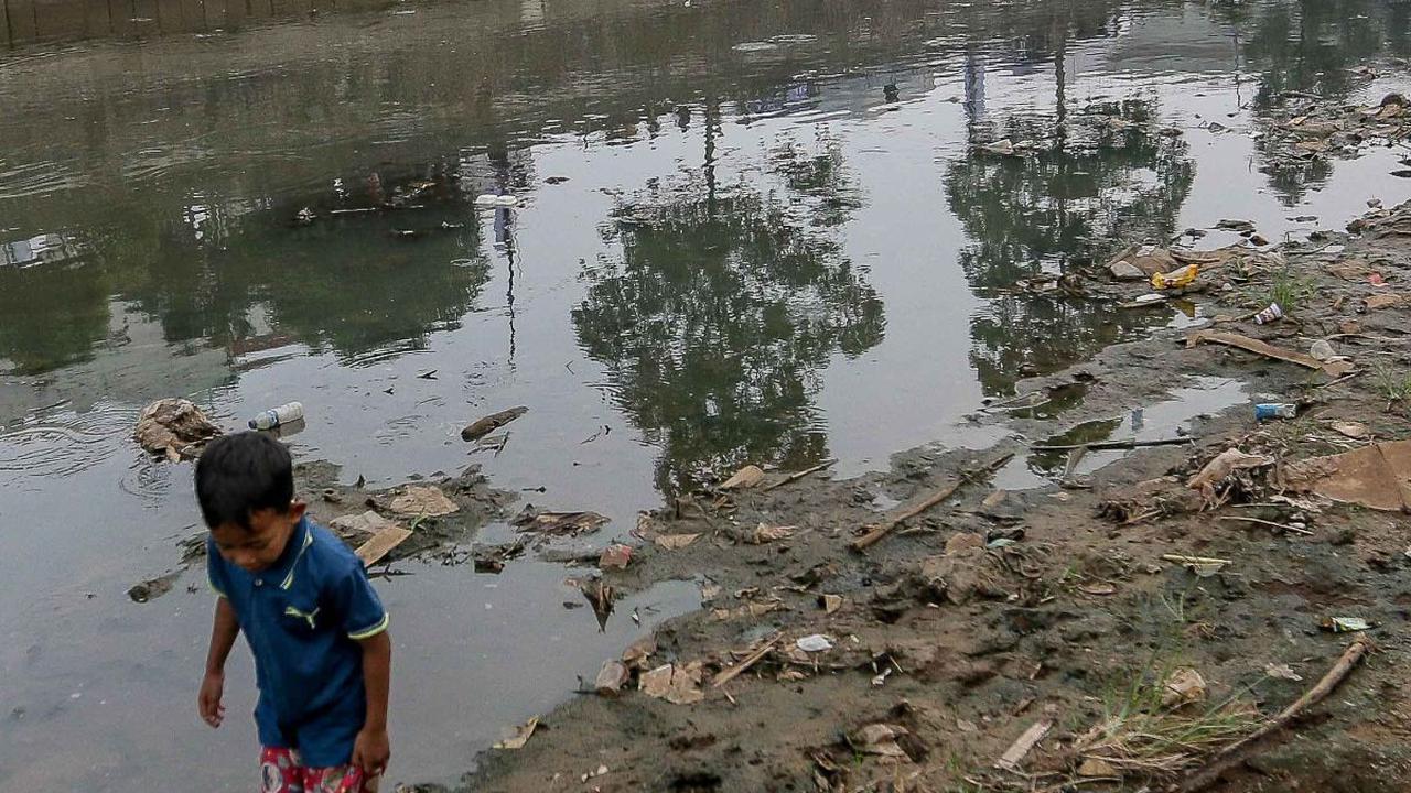 Seorang anak berjalan di tepian Sungai Ciliwung yang menyusut airnya karena kemarau.
