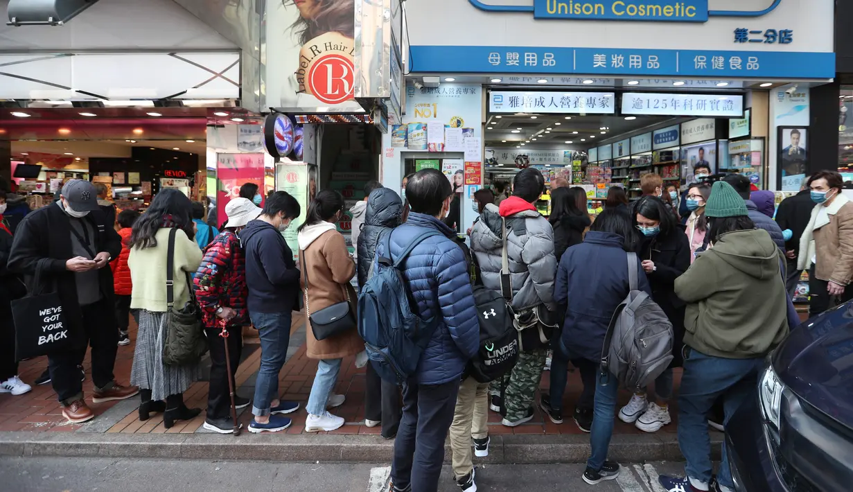 Warga mengantre untuk mendapatkan masker wajah gratis di luar sebuah toko kosmetik di Tsuen Wan, Hong Kong, Selasa (28/1/2020). Hong Kong terkonfirmasi memiliki delapan kasus infeksi virus corona. (AP Photo/Achmad Ibrahim)