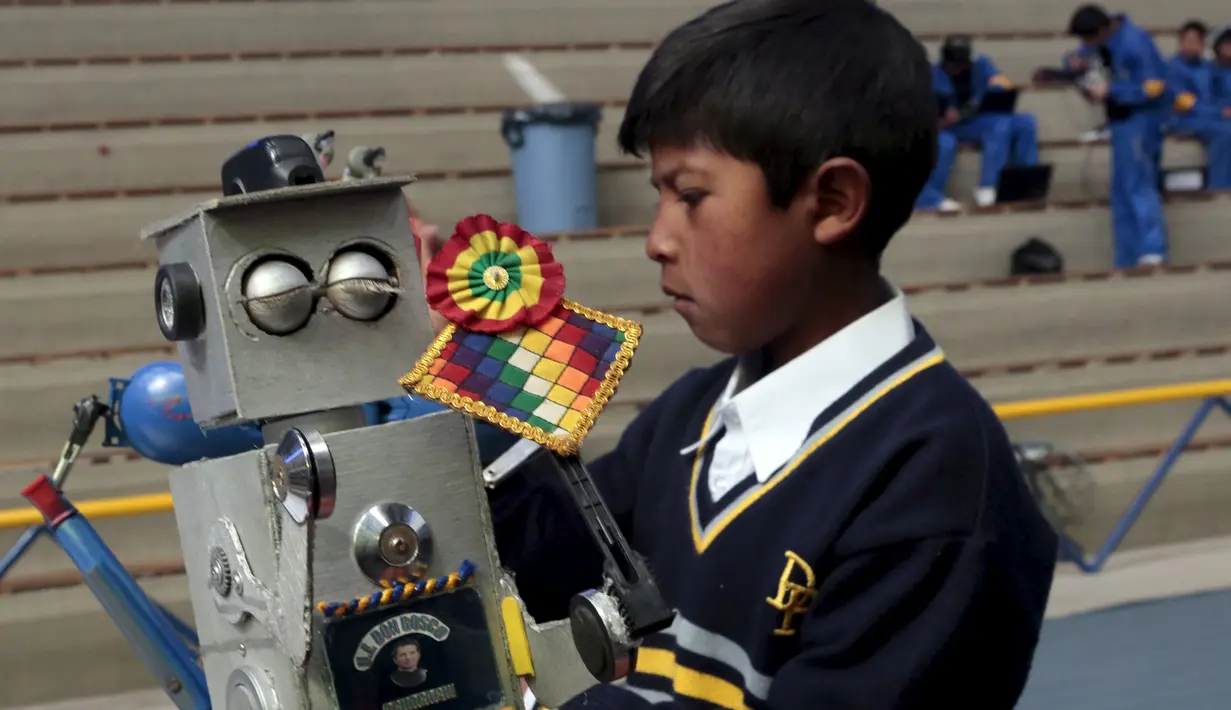 Seorang anak sedang sibuk memasang salah satu bagian kepala robotnya pada olimpiade sains di La Paz, Bolivia,  Senin (10/8/2015).  Acara ini didukung oleh kementrian pendidikan Bolivia dan digelar setiap tahun.  (REUTERS/David Mercado)
