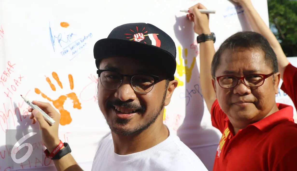 Menteri komunikasi dan informatika, Rudiantara bersama Musisi Giring Nidji menandatangani dekralarasi masyarakat anti hoax di kawasan Car Free Day, Jakarta, Minggu (8/1). (Liputan6.com/Heman Zakharia)
