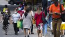 Orang-orang melintas di jalan pada hari pertama masker tidak lagi wajib di Panama City, Panama, Senin (11/7/2022). Masker tidak lagi diperlukan kecuali di rumah sakit dan transportasi umum. (AP Photo/Arnulfo Franco)