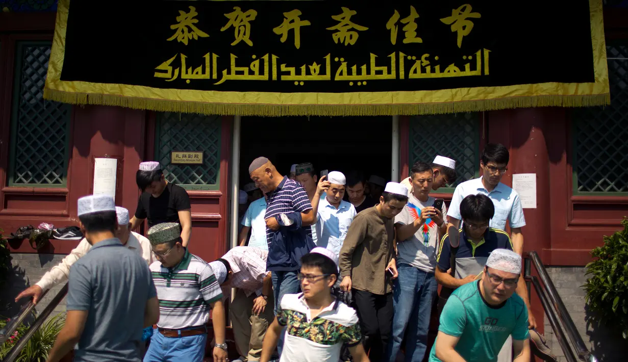 Umat muslim Cina meninggalkan masjid Niujie, Beijing, seusai pelaksanaan salat Idul Fitri, 26 Juni 2017. Masjid Niujie merupakan Masjid bersejarah di Kota Beijing dan mnjadi tempat ibadah masyarakat muslim. (AP Photo/Mark Schiefelbein)