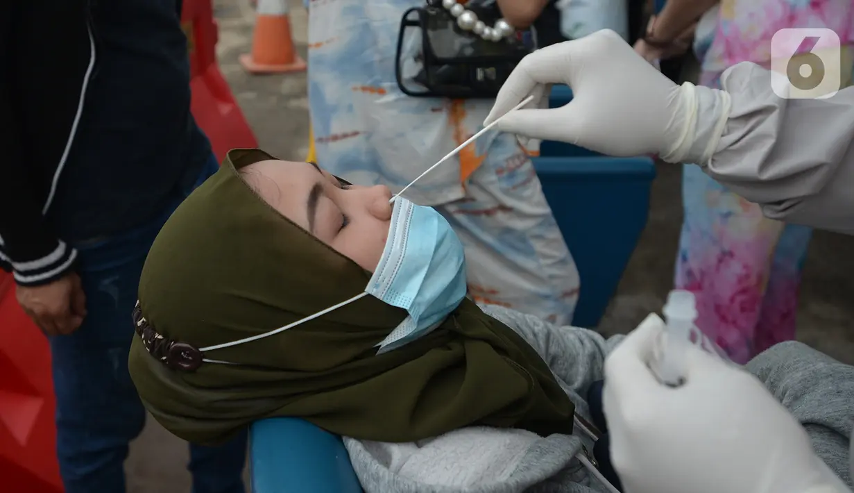 Seorang perempuan menjalani tes usap atau Swab Antigen di Pelabuhan Kali Adem, Jakarta, Kamis (31/12/2020). Pemeriksaan swab antigen kepada wisatawan yang akan liburan Tahun Baru di Kepulauan Seribu dilakukan untuk mencegah penyebaran COVID-19. (merdeka.com/Imam Buhori)