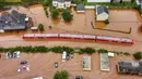 Sebuah kereta api regional terendam banjir setelah dibanjiri oleh tingginya air sungai Kyll di Kordel, Jerman, Kamis (15/7/2021). Sekitar 6.000 orang di munisipalitas Heimerzheim harus dievakuasi, sementara rumah dan harta benda mereka diterjang banjir. (Sebastian Schmitt/dpa via AP)