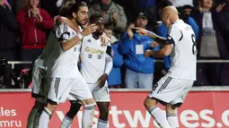 Para pemain Swansea City melakukan selebrasi setelah Chico Flores berhasil menyamakan kedudukan pada pertandingan sepak bola Liga Inggris antara Swansea City vs Hull City di Stadion Liberty, Swansea (10/12/13). (AFP/Geoff Caddick)
