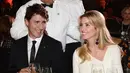 PM Justin Trudeau dan Ivanka Trump tertawa saat KTT Fortune Most Powerful Women dan Gala Museum di Washington, AS (10/10). Ivank tampil dengan busana berwarna putih dan Justin Trudeau mengenakan jas hitam. (Sean Kilpatrick/Canadian Press via AP)