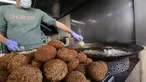 Juru masak Palestina mengenakan sarung tangan dan masker saat menggoreng falafel di sebuah restoran lokal di kota Hebron, Tepi Barat yang diduduki pada 29 April  2020. Pada bulan suci Ramadan, falafel sering dimakan sebagai hidangan buka puasa. (HAZEM BADER / AFP)
