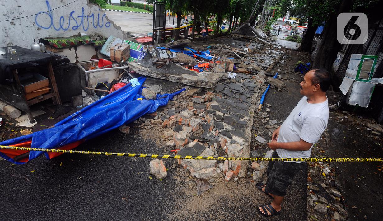 Seorang warga menyaksikan robohnya tembok SPBU yang menewaskan tiga orang di Jalan Tebet Barat Dalam Dua, Jakarta Selatan, Minggu (21/1/2024) siang. (merdeka.com/Arie Basuki)