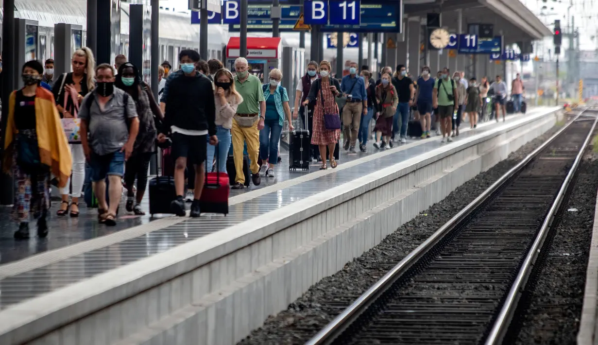 Penumpang berjalan di sepanjang peron di stasiun kereta utama di Frankfurt, Jerman, Jumat (14/8/2020). Mengenakan masker untuk melindungi diri dari corona Covid-19 adalah kewajiban di transportasi umum di Jerman. (AP Photo/Michael Probst)