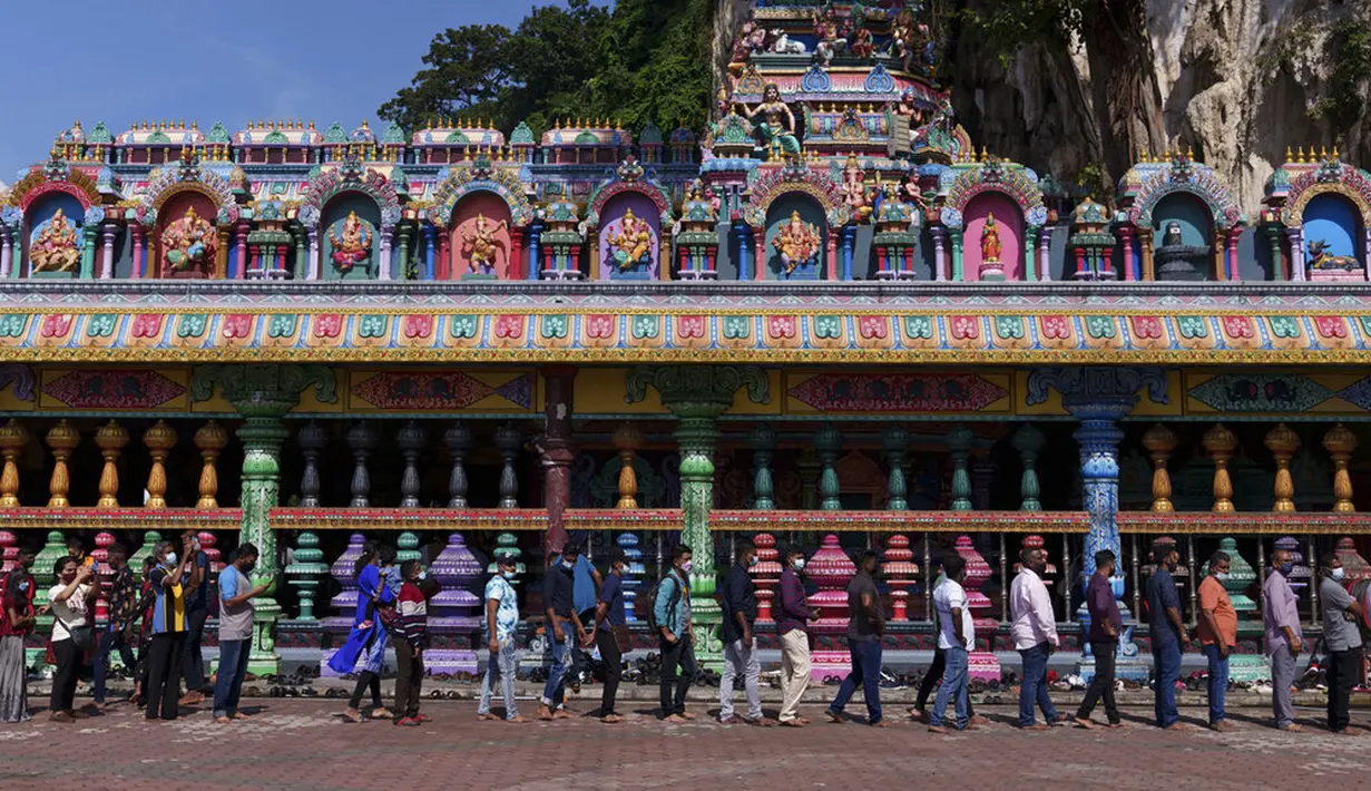 Umat Hindu berbaris untuk berdoa saat Festival Diwali di Kuil Batu Caves, Kuala Lumpur, Malaysia, Kamis (4/11/2021). Diwali adalah salah satu festival terpenting dalam agama Hindu, didedikasikan untuk penyembahan dewi kekayaan Lakshmi. (AP Photo/Vincent Thian)