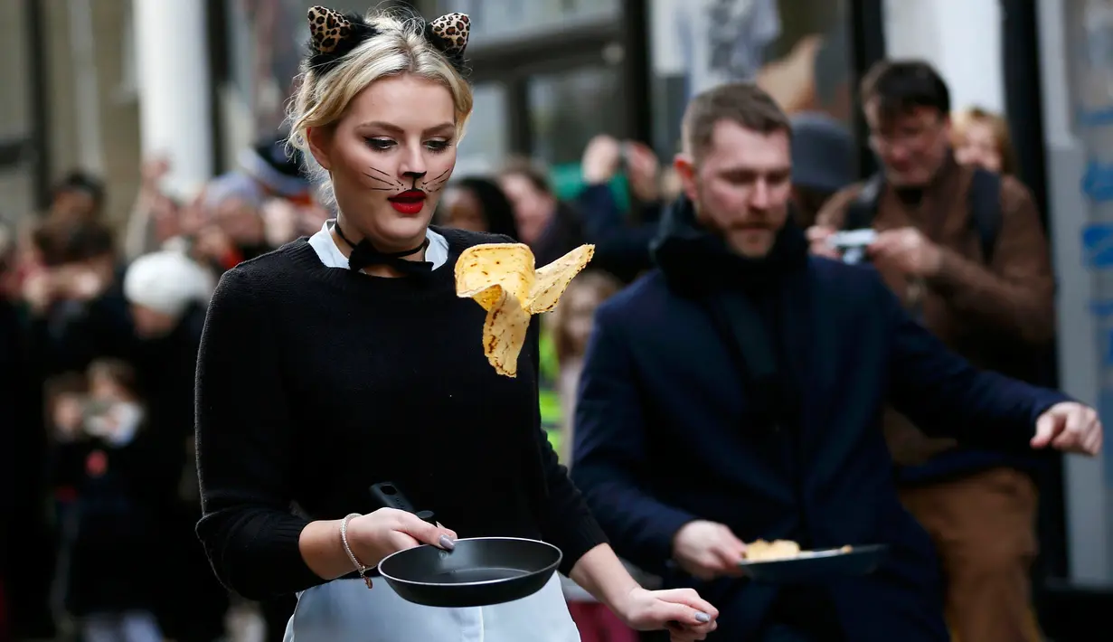 Seorang peserta ikut ambil bagian dalam acara tahunan Great Spitalfields Pancake Race untuk mengumpulkan uang bagi Ambulan Udara London di Inggris, Selasa (9/2). (REUTERS/Stefan Wermuth)