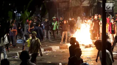 Massa berkumpul dan membakar kardus saat terjadi ricuh akibat unjuk rasa di sekitar jalan Pejompongan, Jakarta, Rabu (25/9/2019). Sebelumnya, unjuk rasa yang dilakukan pelajar STM bentrok dengan aparat kepolisian dibelakang Gedung DPR/MPR. (Liputan6.com/Helmi Fithriansyah)