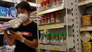 Seorang pelanggan memakai masker ketika berbelanja di sebuah supermarket di Hong Kong, Rabu (22/7/2020). Hong Kong telah mewajibkan penggunaan masker di semua area publik tertutup termasuk mal dan pasar seiring penambahan kasus baru harian Covid-19. (AP Photo/Kin Cheung)