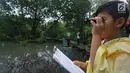 Seorang anak memantau aktivitas burung pada kegiatan Asian Waterbird Census 2019 di Hutan Lindung Angke Kapuk Jakarta, Sabtu (19/1). Kegiatan yang diinisiasi Yayasan KEHATI ini bertujuan memperkenalkan keanekaragaman hayati. (Liputan6.com/Fery Pradolo)