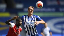 Pemain Brighton & Hove Albion, Dan Burn, berebut bola dengan pemain Arsenal, Nicolas Pepe, pada laga Premier League di Stadion Falmer, Sabtu (20/6/2020). Arsenal kalah 1-2. (AP/Mike Hewitt)