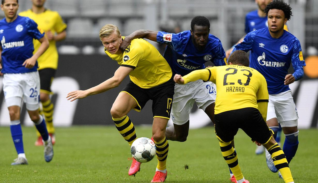 Penyerang Borussia Dortmund, Erling Haaland, berusaha melewati pemain Schalke 04 pada laga Bundesliga di Stadion Signal Iduna Park, Sabtu (16/5/2020). Dortmund menang 4-0 atas Schalke 04. (AP/Martin Meissner)