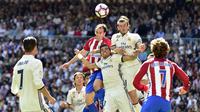 Duel udara bek Atletico Madrid, Diego Godin kontra pemain Real Madrid, Gareth Bale, pada laga lanjutan La Liga 2016-2017, di Stadion Santiago Bernabeu, Sabtu (8/4/2017) malam WIB. (AFP/Gerard Julien)