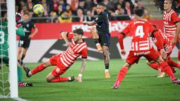 Pemain Atletico Madrid Memphis Depay (tengah) menantang kiper Girona Paulo Gazzaniga pada pertandingan sepak bola Liga Spanyol di Stadion Montilivi, Girona, Spanyol, 13 Maret 2023. Gol tunggal Alvaro Morata membawa Atletico Madrid mengalahkan Girona. (LLUIS GENE/AFP)