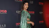 Wanita cantik kelahiran India ini memadukan penampilannya dengan sepatu hak tinggi berwarna emas. (Dimitrios Kambouris/Getty Images for DKMS Gala/AFP)