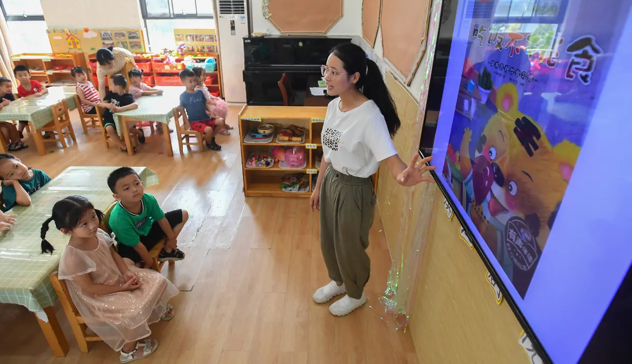 Seorang guru bercerita sebelum waktu makan di sebuah taman kanak-kanak di Changsha, Provinsi Hunan, China, 2 September 2020. Taman kanak-kanak tersebut menumbuhkan kesadaran anak-anak untuk menghargai makanan sejak usia dini dan membantu mereka membentuk kebiasaan makan yang baik (Xinhua/Chen Zeguo)