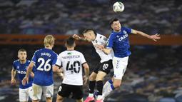 Bek Everton, Michael Keane, berebut bola atas dengan penyerang Salford City, Ashley Hunter, pada laga Piala Inggris di Stadion Goodison Park, Kamis (17/9/2020) dini hari WIB. Everton menang 3-0 atas Salford City. (AFP/Peter Powell/pool)
