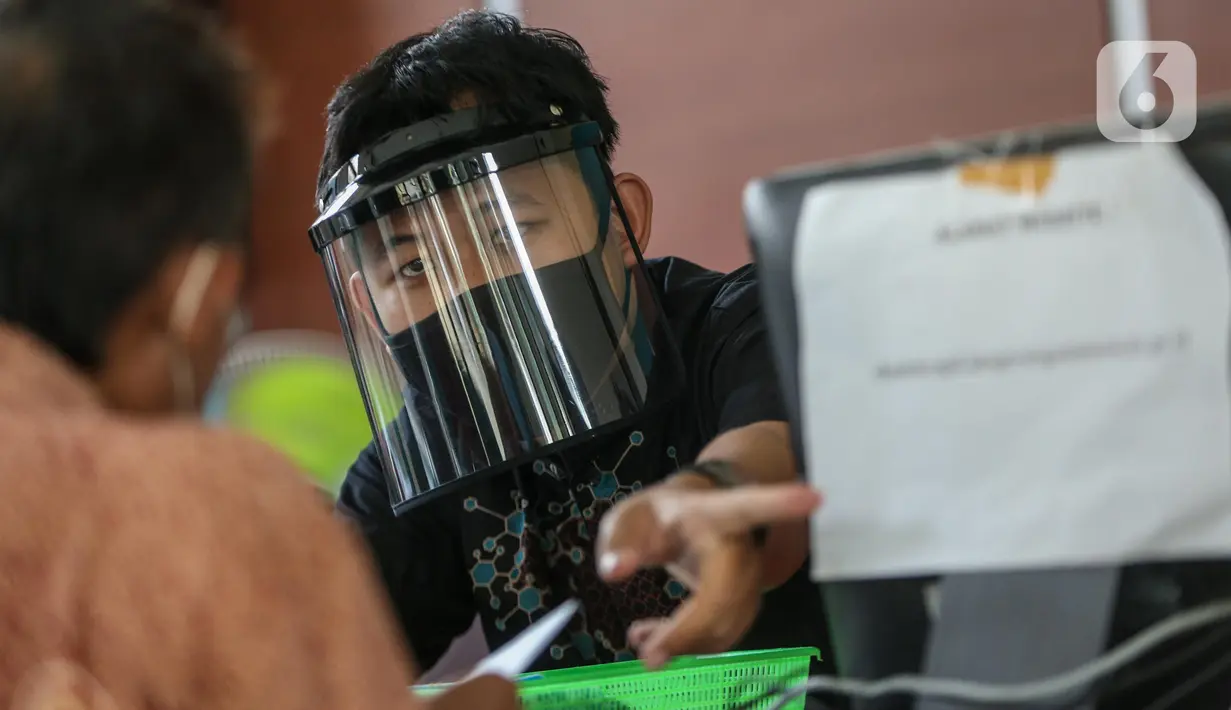 Petugas menggunakan face shield saat melayani masyarakat Dinas Kependudukan Kecamatan Pamulang, Tangerang Selatan, Jumat (29/5/2020).  Penggunaan Face Shield tersebut sebagai salah satu upaya untuk melindungi diri dalam penyebaran COVID-19. (Liputan6.com/Faizal Fanani)