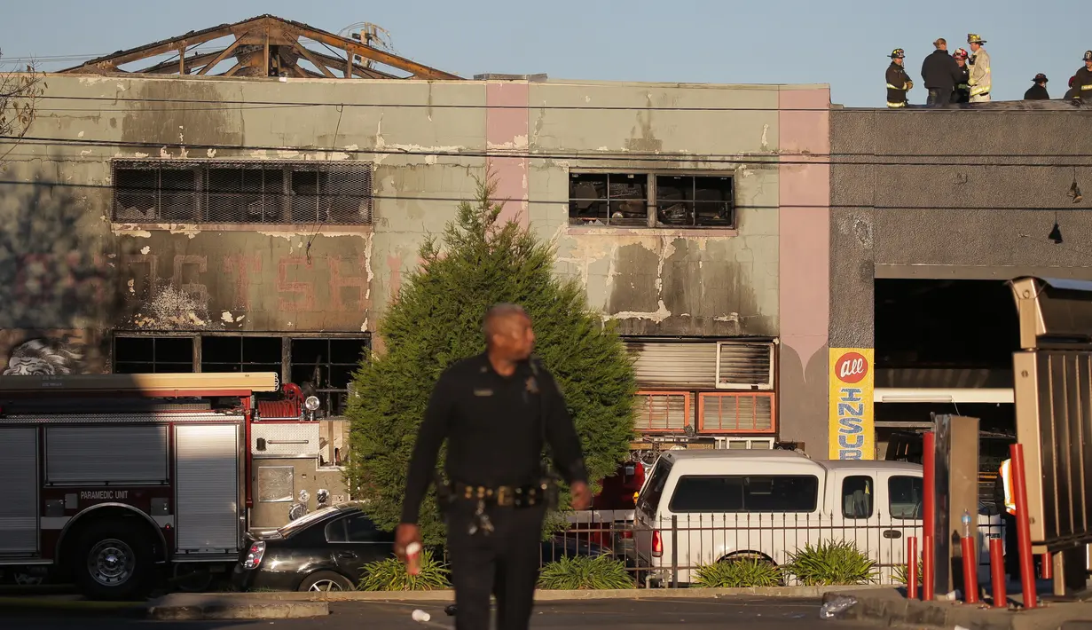 Polisi dan petugas pemadam masih berada di sebuah kelab malam yang mengalami kebakaran di Oakland, California, Sabtu (3/12). Pihak berwenang memperkirakan korban tewas bisa meningkat mencapai 40. (Elijah Nouvelage/GETTY IMAGES NORTH AMERICA/AFP)