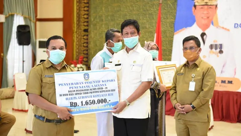 Pelaksana Tugas (Plt) Gubernur Kepri Isdianto menyerahkan insentif kepada dokter, perawat, tenaga kesehatan di Gedung Daerah, Tanjungpinang, Senin (30/3/2020). (Ajang/Liputan6.com)