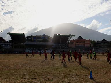 Suasana&nbsp;saat kegiatan&nbsp;coaching clinic di Stadion Gelora Kie Raha, Ternate, dengan latar gunung Gamalama, Minggu (13/8/2023) sore hari WIT. (Bola.com/Okie Prabhowo)