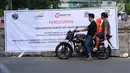 Warga membaca spanduk sosialisasi penutupan perlintasan kereta di Jalan Angkasa, Jakarta, Minggu (15/10). Penutupan secara permanen perlintasan KA di Jalan Angkasa akan dilakukan pada 3 November mendatang. (Liputan6.com/Helmi Fithriansyah)