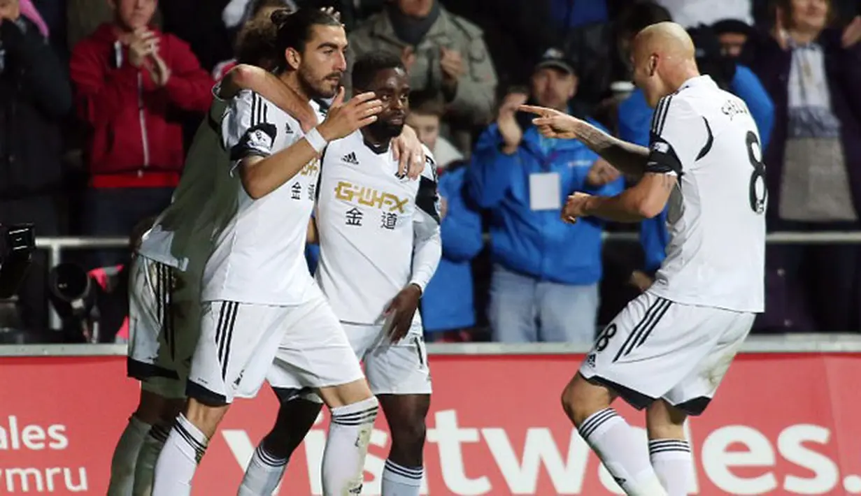 Para pemain Swansea City melakukan selebrasi setelah Chico Flores berhasil menyamakan kedudukan pada pertandingan sepak bola Liga Inggris antara Swansea City vs Hull City di Stadion Liberty, Swansea (10/12/13). (AFP/Geoff Caddick)